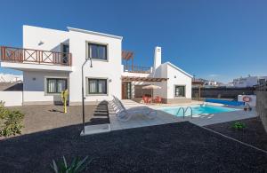 a villa with a swimming pool and a house at Villas Camelot by LIVVO in Playa Blanca