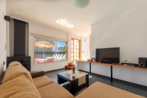 a living room with a couch and a flat screen tv at Villas Camelot by LIVVO in Playa Blanca