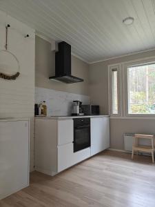 a kitchen with white cabinets and a window at Sunstar Villa in Rovaniemi