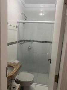 a bathroom with a toilet and a glass shower at Upper Hotel in Sao Paulo