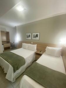 ein Hotelzimmer mit 2 Betten und einem Tisch in der Unterkunft Upper Hotel in São Paulo