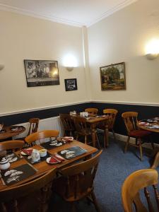 uma sala de jantar com mesas e cadeiras de madeira em Y Garth Guesthouse em Bangor