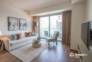a living room with a couch and a tv at Dream Inn Dubai Apartments- Premium 1BR Connected to Dubai Marina Mall in Dubai