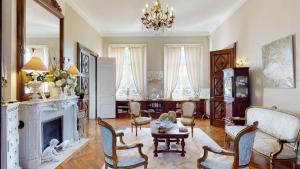 a living room with a fireplace and a table and chairs at Château "Le Castel des Anges" in Wailly-Beaucamp