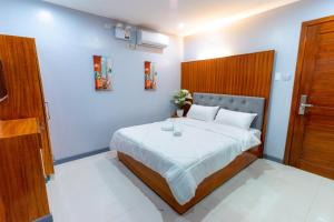 Schlafzimmer mit einem großen Bett mit einem Kopfteil aus Holz in der Unterkunft Grand Mercy Hotel in Calbayog