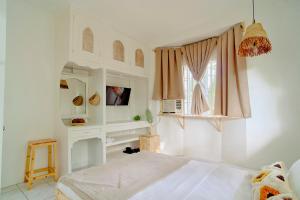 a white bedroom with a bed and a window at Pallet Homes - Landheights Tropics in Iloilo City