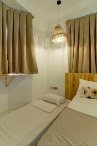 una camera con due letti e un lampadario a braccio di Pallet Homes - Landheights Tropics a Città di Iloilo