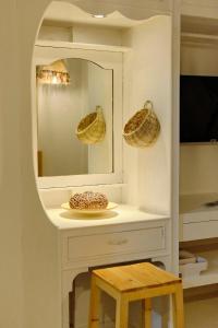 a white cabinet with a mirror and a stool at Pallet Homes - Landheights Tropics in Iloilo City