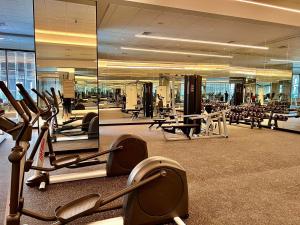 a gym with cardio equipment in a large building at Condo with nearest to JIExpo 55” SMART TV (Netflix & Disney) and Wi-fi 50mb in Jakarta