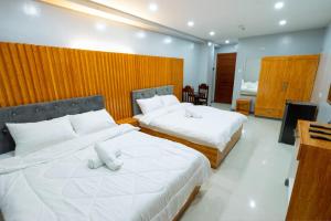 a bedroom with two beds with white pillows at Grand Mercy Hotel in Calbayog