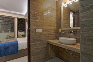 bagno con lavandino e letto di Cardinal Express Oxmo a Nuova Delhi