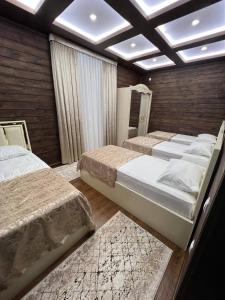 a bedroom with three beds in a room with a ceiling at Amirsoy Apple Dacha in Chimgan