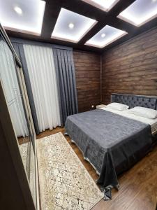 a bedroom with a bed and wooden walls at Amirsoy Apple Dacha in Chimgan