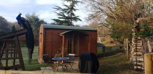 a small wooden shed with a table and a chair at Sika hut in Wareham