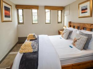 a bedroom with a bed with white sheets and pillows at The Cow Shed in Holmfirth