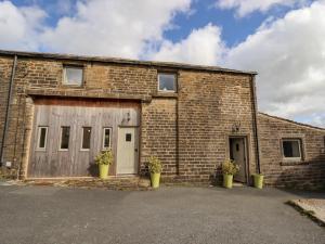 a brick building with two doors and two potted plants at The Hayloft in Holmfirth