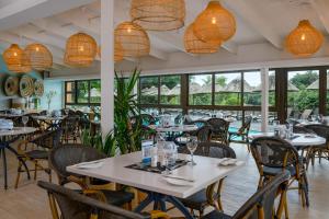 un restaurante con mesas, sillas y lámparas de araña en San Lameer Villa 3503 - 4 Bedroom Standard- 8 pax - San Lameer Rental Agency, en Southbroom