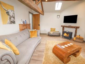 a living room with a couch and a fireplace at The Hayloft in Holmfirth