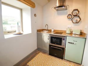 una cucina con lavandino e forno a microonde di The Hayloft a Holmfirth