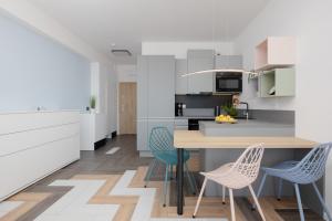 a kitchen with a wooden table and chairs at Sea View Studio Apartment Porta Mare by Renters Prestige in Dziwnówek