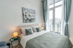 Un dormitorio con una cama grande y una ventana en Vibrant 1-bdr Apt Wpoolgym Near Airport Metro, en Estambul