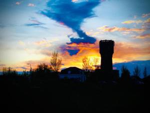 a silhouette of a silo in front of a sunset at Torenkamer op de vijfde verdieping van de watertoren van Strijen in Strijen