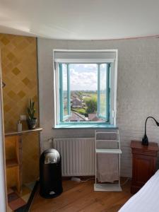 una camera da letto con finestra affacciata sulla città di Torenkamer op de vijfde verdieping van de watertoren van Strijen a Strijen