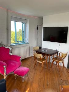un soggiorno con un divano rosso e un tavolo di Torenkamer op de vijfde verdieping van de watertoren van Strijen a Strijen Altre 4 foto