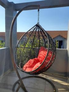a hanging hammock with a red pillow in it at Lovely apartment Back-up power in Sandton