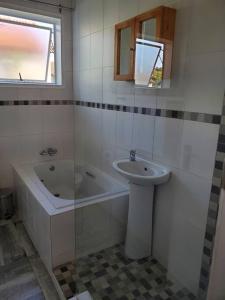 a bathroom with a tub and a sink and a bath tub at Lovely apartment Back-up power in Sandton +14 photos