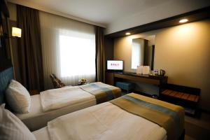 Habitación de hotel con 2 camas y espejo en Fier Life Center en Kayseri