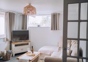 a living room with a couch and a tv at Joannes Retreat, Dog Friendly Property in Weymouth with Free Parking in Weymouth
