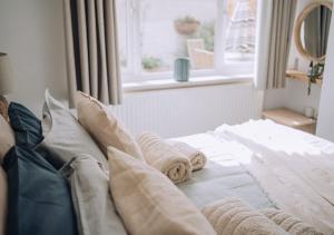 - une chambre avec un lit doté d'oreillers et d'une fenêtre dans l'établissement Joannes Retreat, Dog Friendly Property in Weymouth with Free Parking, à Weymouth