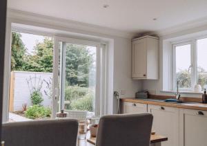 a kitchen with a large window and a table and chairs at Joannes Retreat, Dog Friendly Property in Weymouth with Free Parking in Weymouth