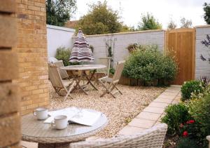 a patio with a table and chairs in a backyard at Joannes Retreat, Dog Friendly Property in Weymouth with Free Parking in Weymouth