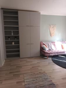 a living room with a couch and a closet at Saunallinen yksiö, 4 vuodepaikka in Eura