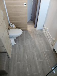 a bathroom with a toilet and a tile floor at Le SerenityAppart Suresnes in Suresnes