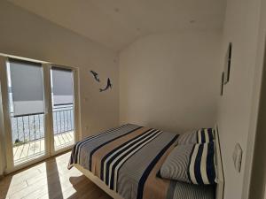 a bedroom with a bed and a large window at Sea view Apartment in Mimice