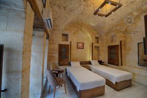 sypialnia z 2 łóżkami w kamiennej ścianie w obiekcie Vefa Konagı Boutique Otel w mieście Şanlıurfa