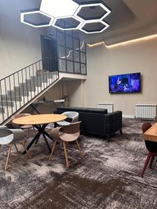 a room with tables and chairs and a couch at AQ Capsule Hotel in Almaty