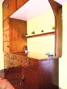 a wooden dresser with a mirror on top of it at Hidden Monkey Hostels in Darjeeling