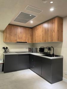 a kitchen with wooden cabinets and a black counter top at AQ Capsule Hotel in Almaty