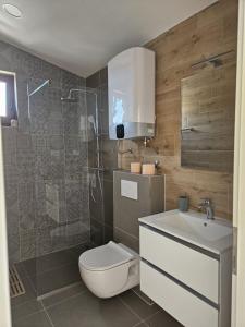 a bathroom with a toilet and a sink and a shower at Sea view Apartment in Mimice +38 photos