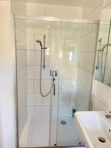 um chuveiro com uma porta de vidro ao lado de um lavatório em Gasthaus Sonnenblume em Salzburgo