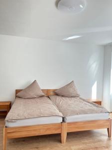 a bed with a wooden frame in a room at Gasthaus Sonnenblume in Salzburg