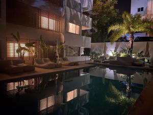 una piscina por la noche junto a un edificio en Brasil Suites Boutique Hotel, en Atenas