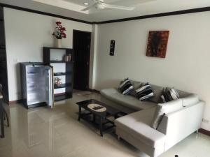 uma sala de estar com um sofá e uma mesa em BEA Privileged Apartment em Lamai