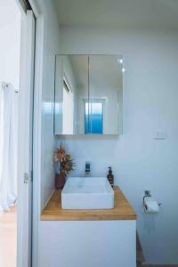 ein Badezimmer mit einem weißen Waschbecken und einem Spiegel in der Unterkunft Hampton Bliss Kiama in Kiama Downs