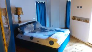 1 dormitorio con cama azul y cortinas azules en Gelsomino House, en Vogogna