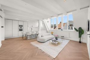 ein weißes Wohnzimmer mit einem weißen Sofa und einem Tisch in der Unterkunft Designer Penthouse with Balcony in Wien